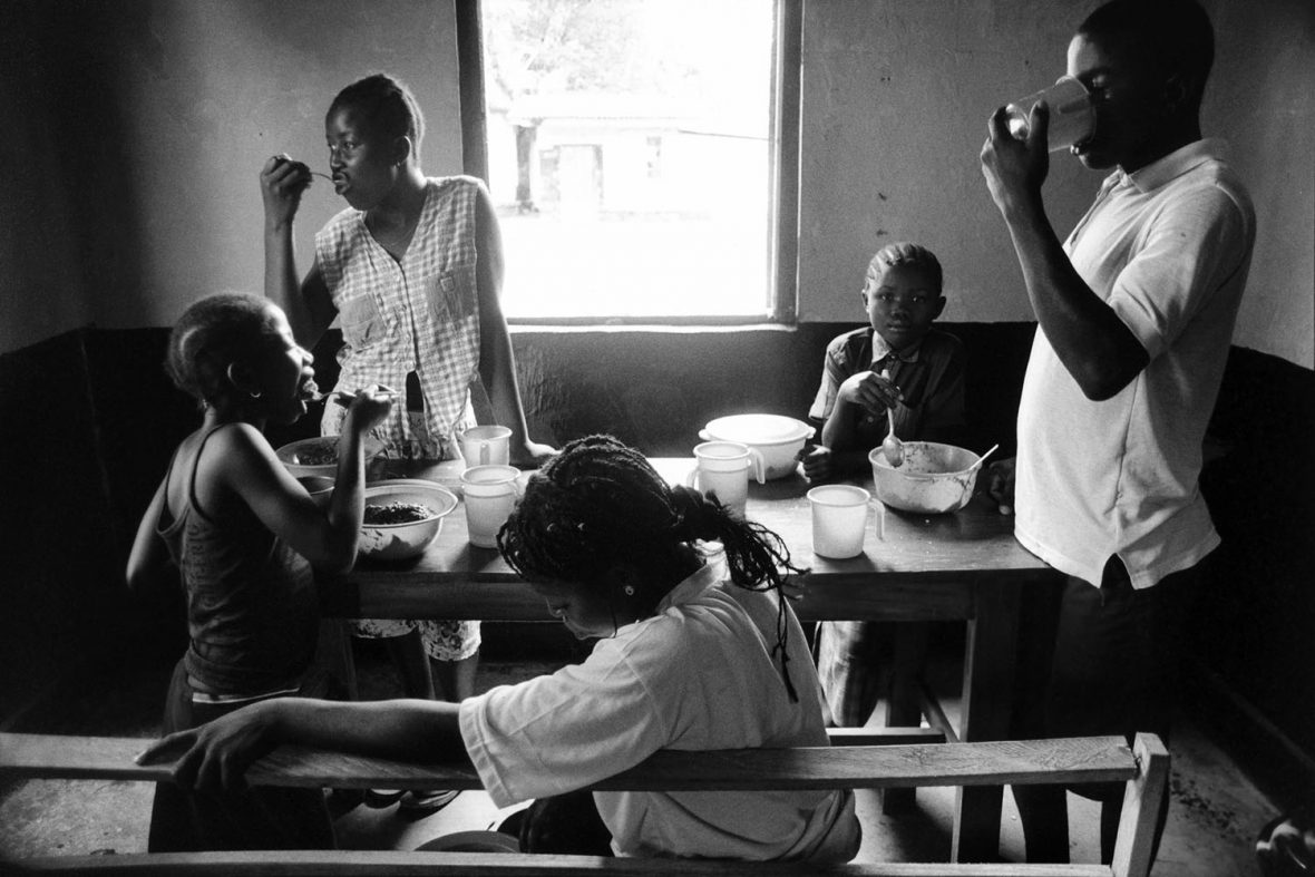 In 2002, shortly after Sierra Leone's decade-long civil war ended, I was commissioned by UNICEF to photograph their rehabilitation work with recently deweaponised child soldiers. This is lunch time at a care centre in Yengema, Koidu, for children who had been separated from their families during the conflict; most of them had spent time with the rebel army. The centre was run by the International Rescue Committee. A few days after I took this picture, I saw the three children on the right side of the picture (left to right: Bintu Kpakima, 12, Rebecca Fillie, 10, and Komba Kanessie, 14) reunited with their families.