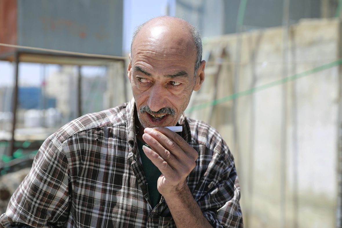 Marwan Aktaa, 60, a refugee from Homs, Syria, on the roof terrace outside the flat he rents in Amman.

Marwan came to Jordan with his family in 2013, arriving in Zaatari camp where they spent one day, then moved to Amman. 

His wife, Yusra Oudeh, is 59 and together they have six children, living in Jordan, Turkey and Lebanon. All the children are married except for the youngest, Mohammad, 22, who lives with his parents. Mohammad dropped out of school once he arrived in Jordan; he occasionally works at a bakery. 

Marwan used to be a plumber in Syria, but now, due to his age and his medical condition (slipped disc), he has stopped working. Marwan has his sisters in Syria, but he has two siblings in Jordan. 

His landlord in Amman keeps pigeons on the roof terrace outside his flat, which Marwan helps look after in exchange for a rent reduction.  He used to look after pigeons in Syria and loves being with them: feeding them, letting them in and out of their cages, communicating with them (his wife says he speaks bird).

The family stopped receiving monthly cash assistance and never received food vouchers. The family was identified by the resettlement unit as being eligible to be relocated to a third country; if this is confirmed, it is likely to be Norway, Canada or the USA.