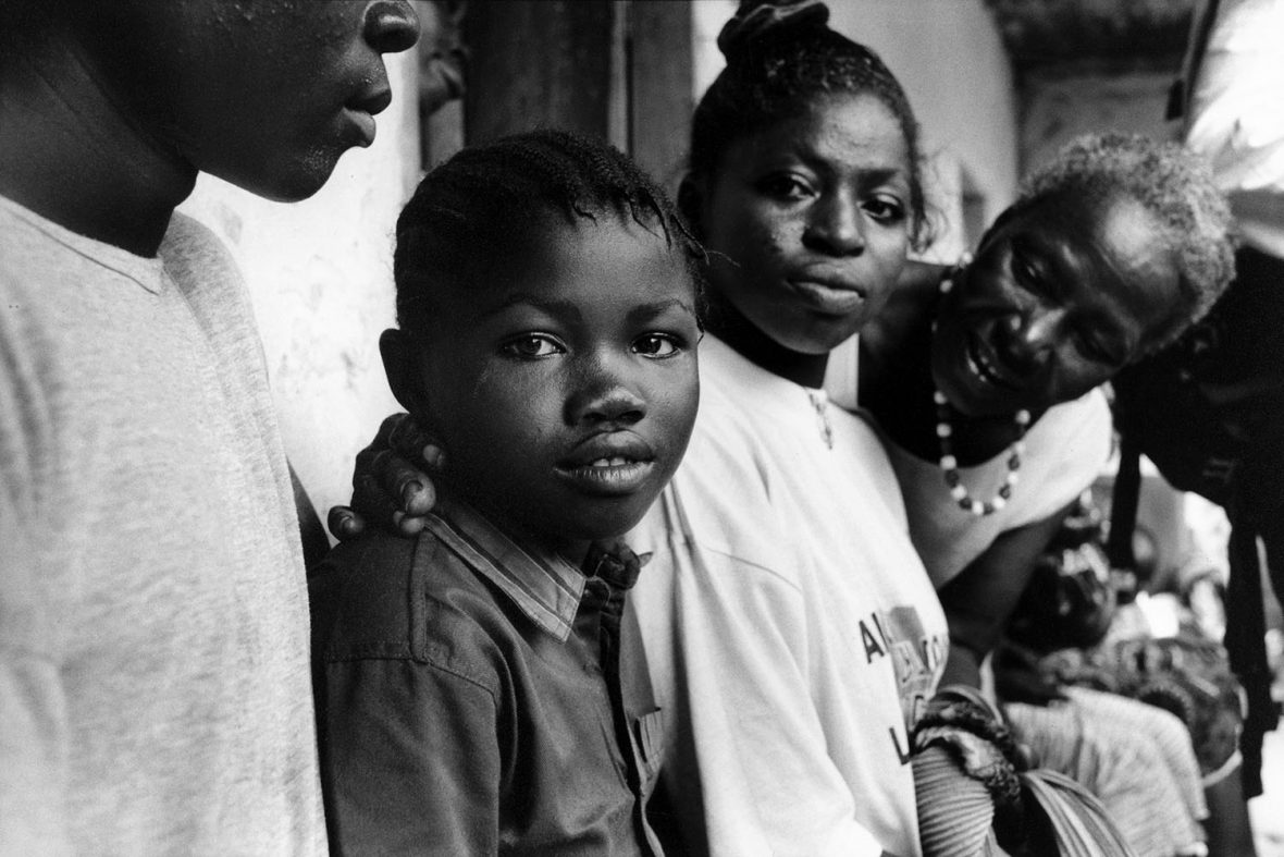 Rebecca Fillie, centre, and Bintu Kpakima, right, moments after being reunified with family in 2002, following several years of separation during the war